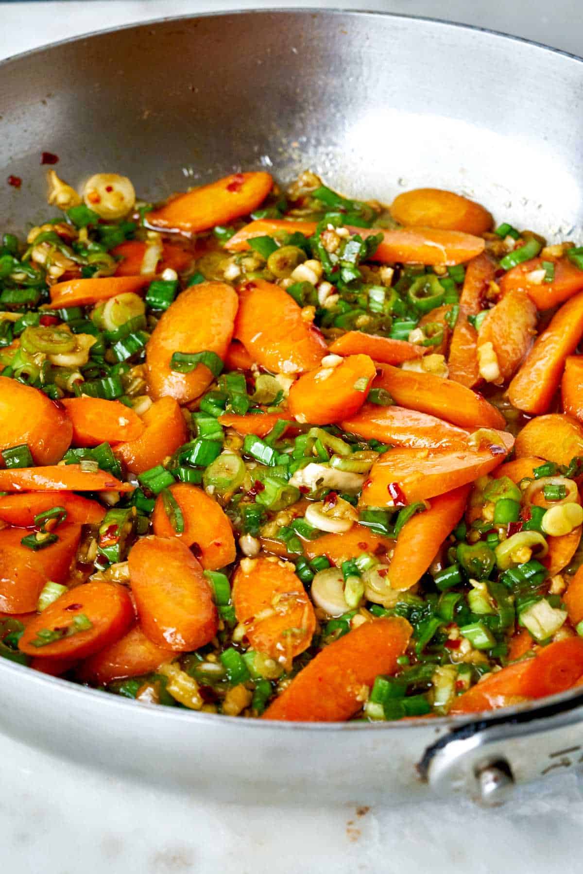 Carrots and scallions in a pan.