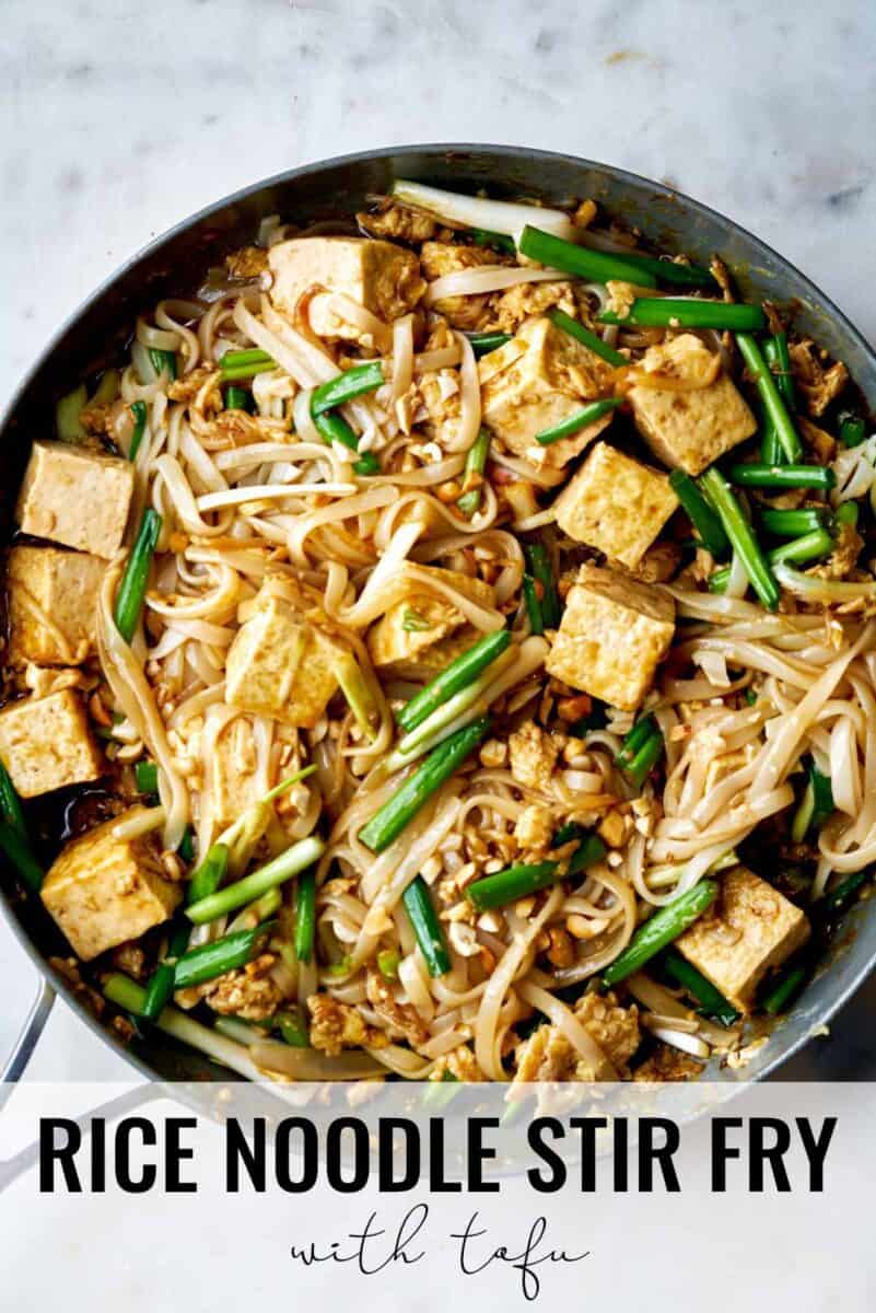 Noodles and tofu in a fry pan.