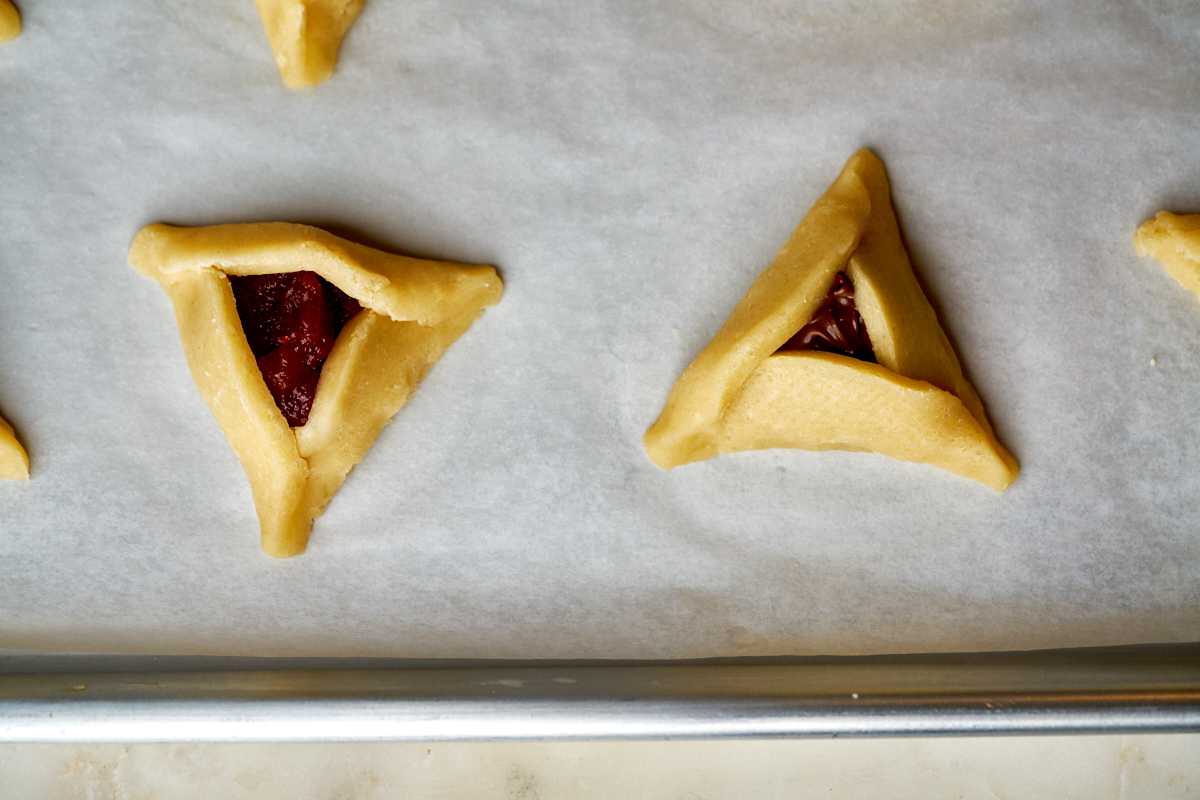 Triangle cookies on a baking sheet.