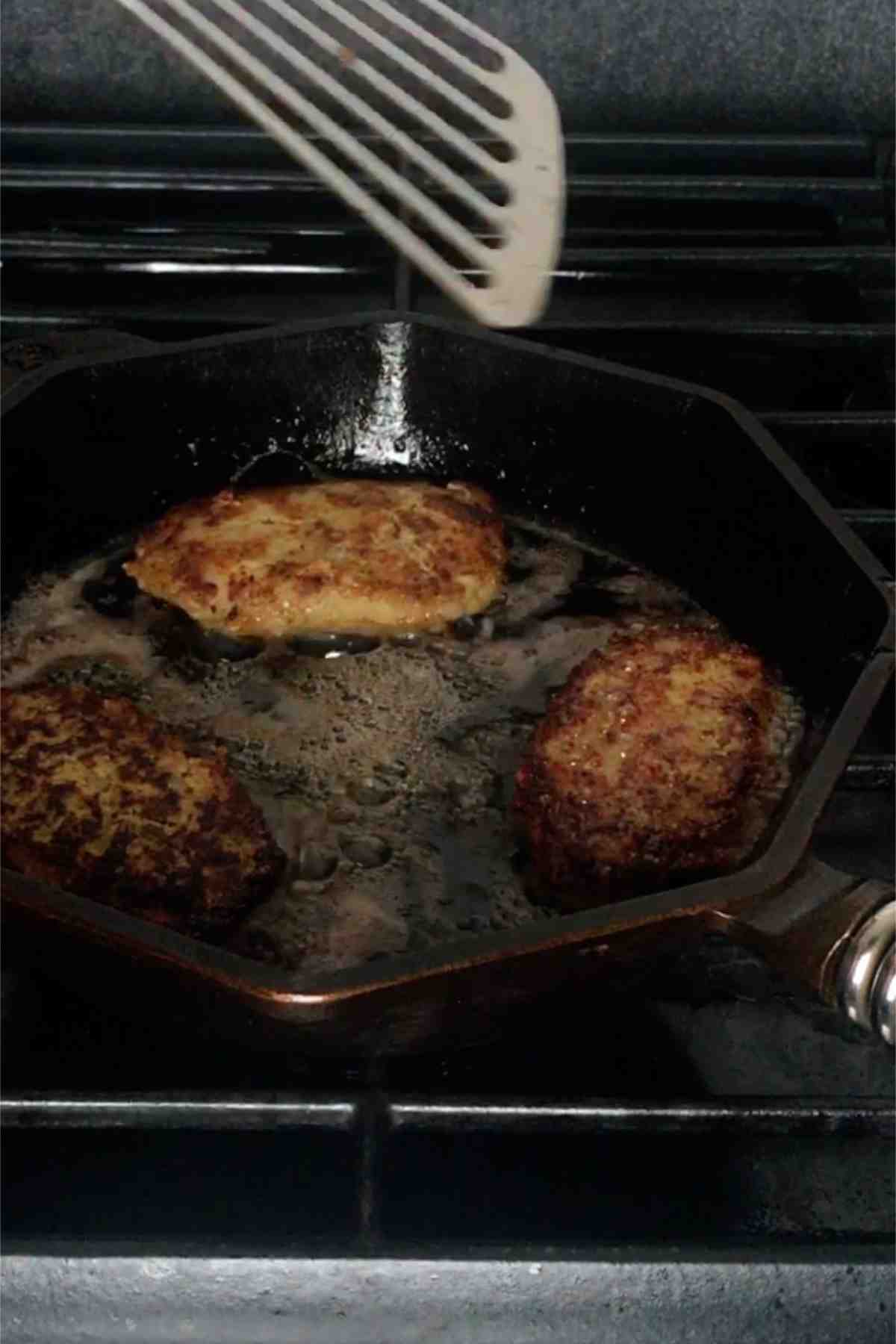 Frying patties in a pan.