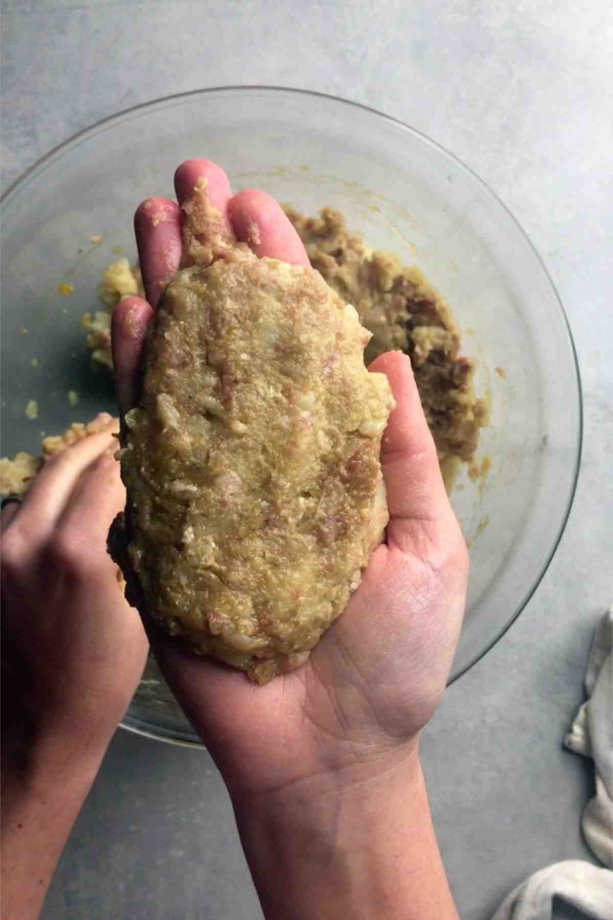 Meat and potato patty in a hand.