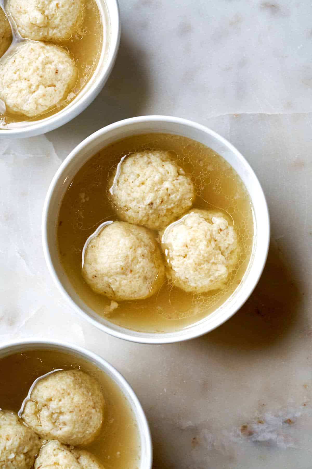 Three bowls of matzo ball soup.