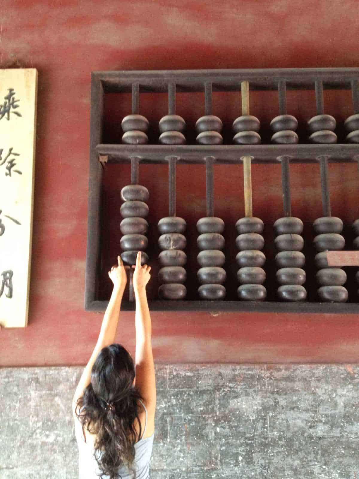 Woman moving a giant abacus.