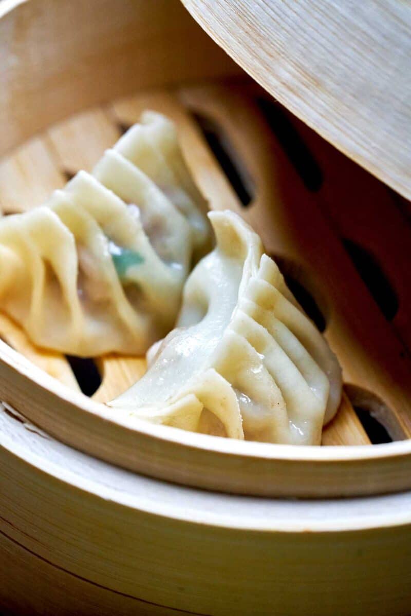 Two dumplings in a small steamer.