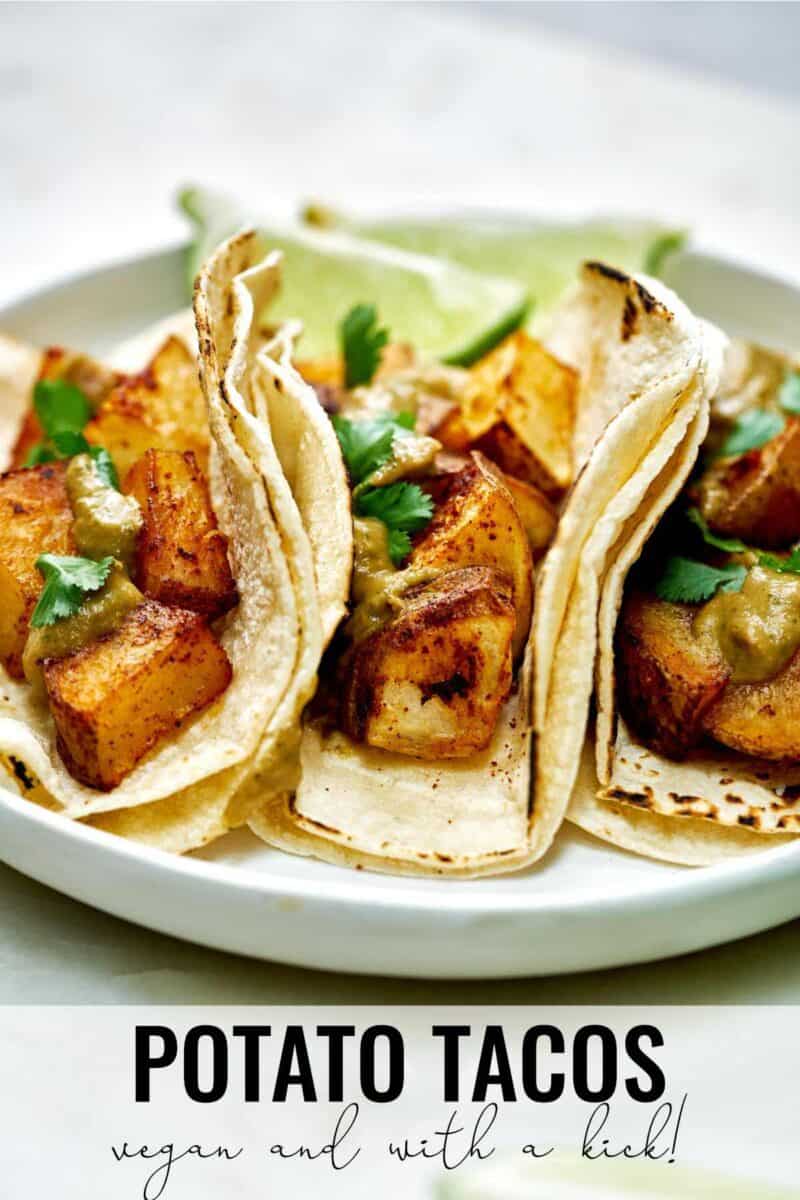 Three potato tacos with cilantro and lime.