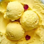 Scoops of yellow ice cream with rose petals.