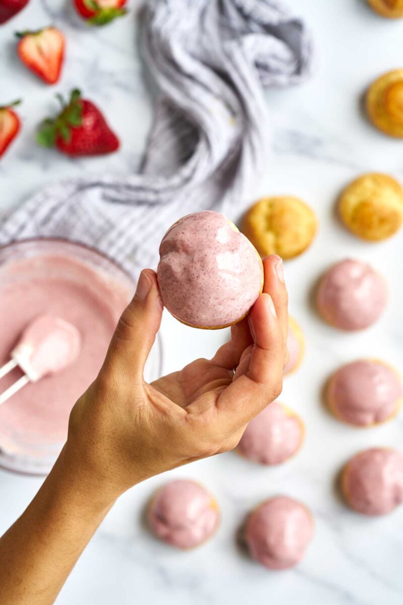 Pink cream puff in a hand.