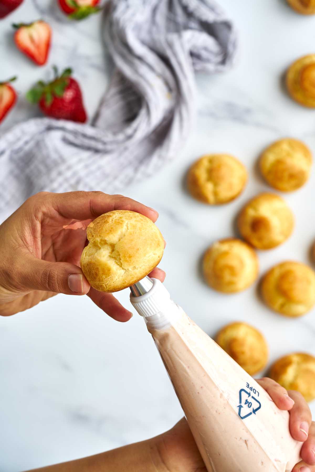 Filling choux ball with pink filling.