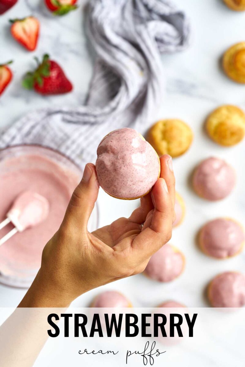 Pink cream puff in a hand.