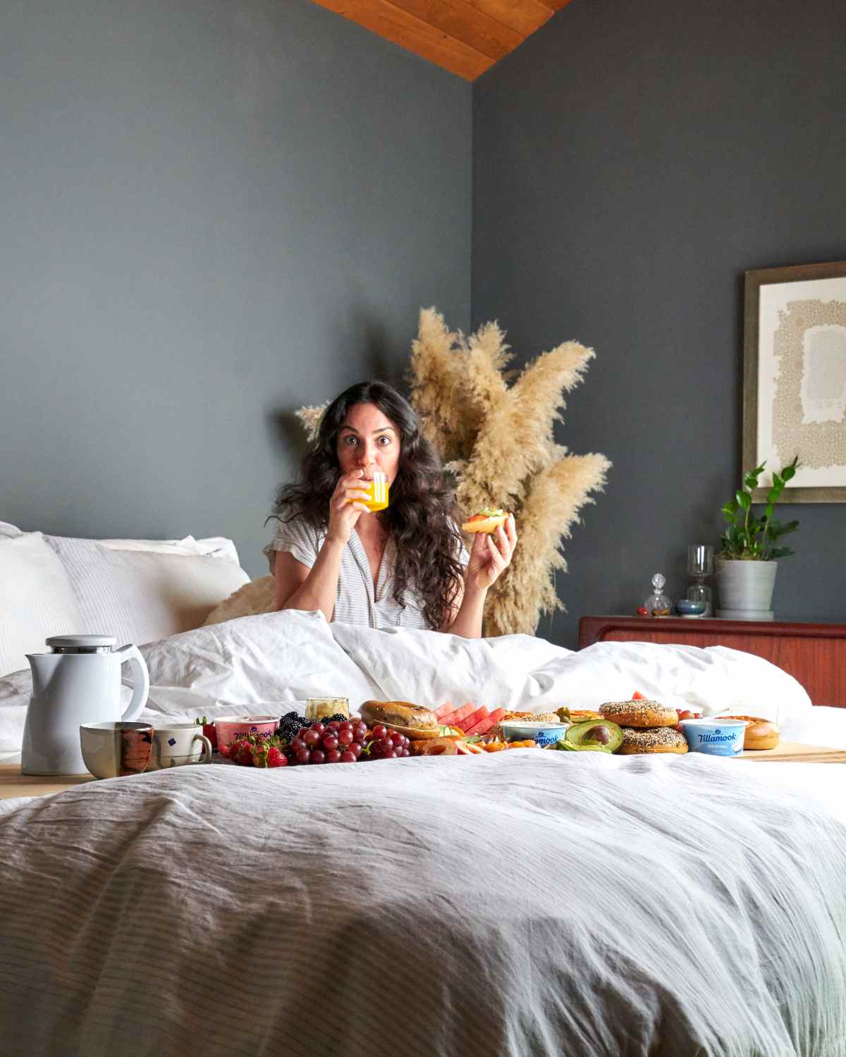 Woman in bed eating breakfast.