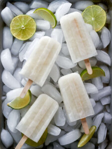 White popsicles over ice with limes.