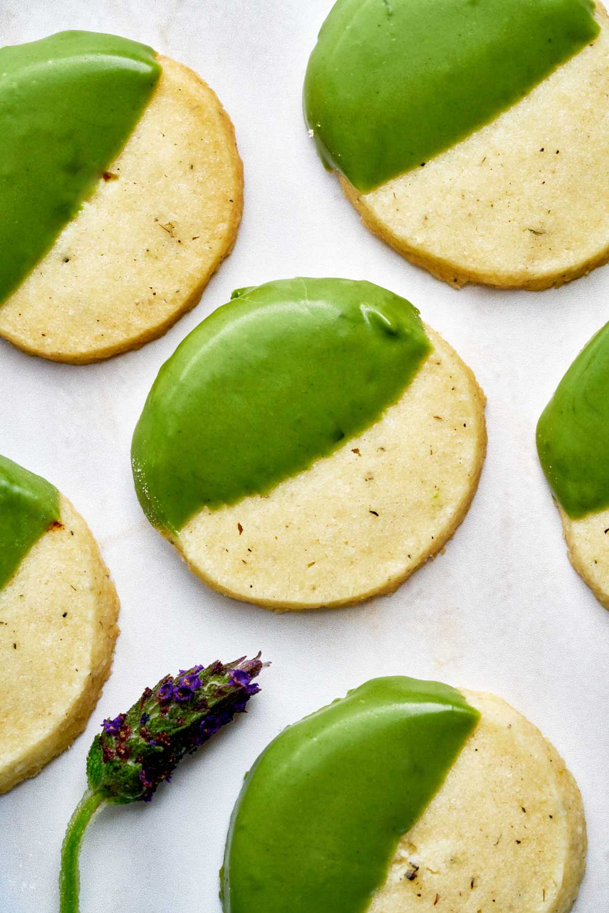 Green dipped shortbread cookies with a sprig of lavender.