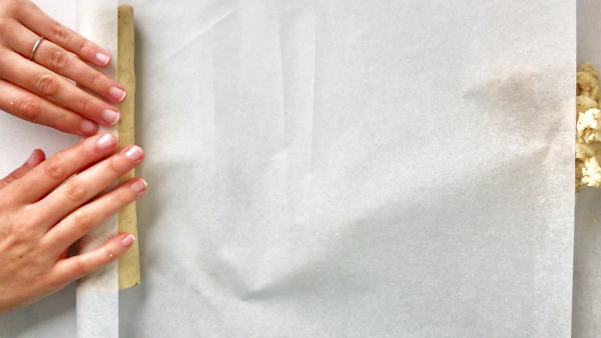 Rolling cookie dough in parchment paper.