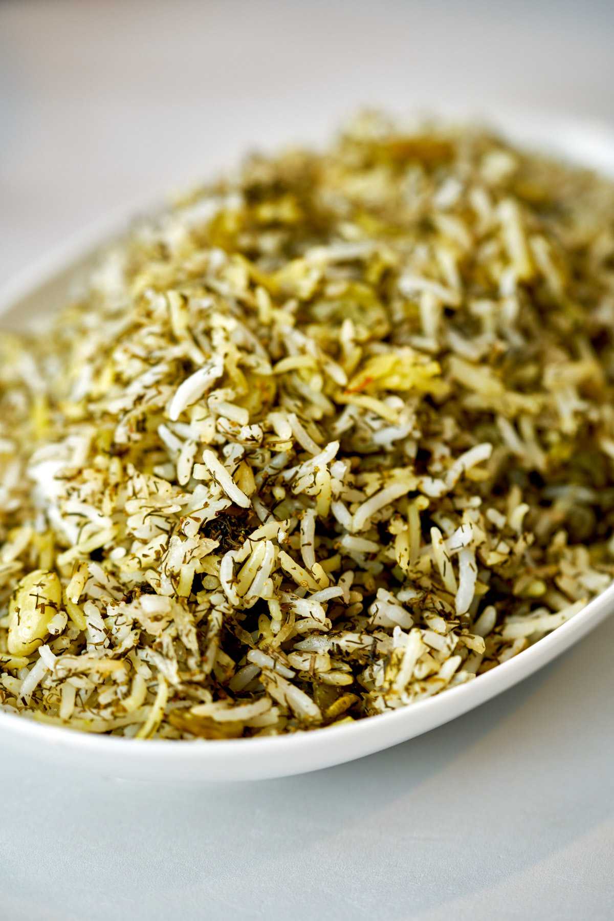 Green rice in a white dish.