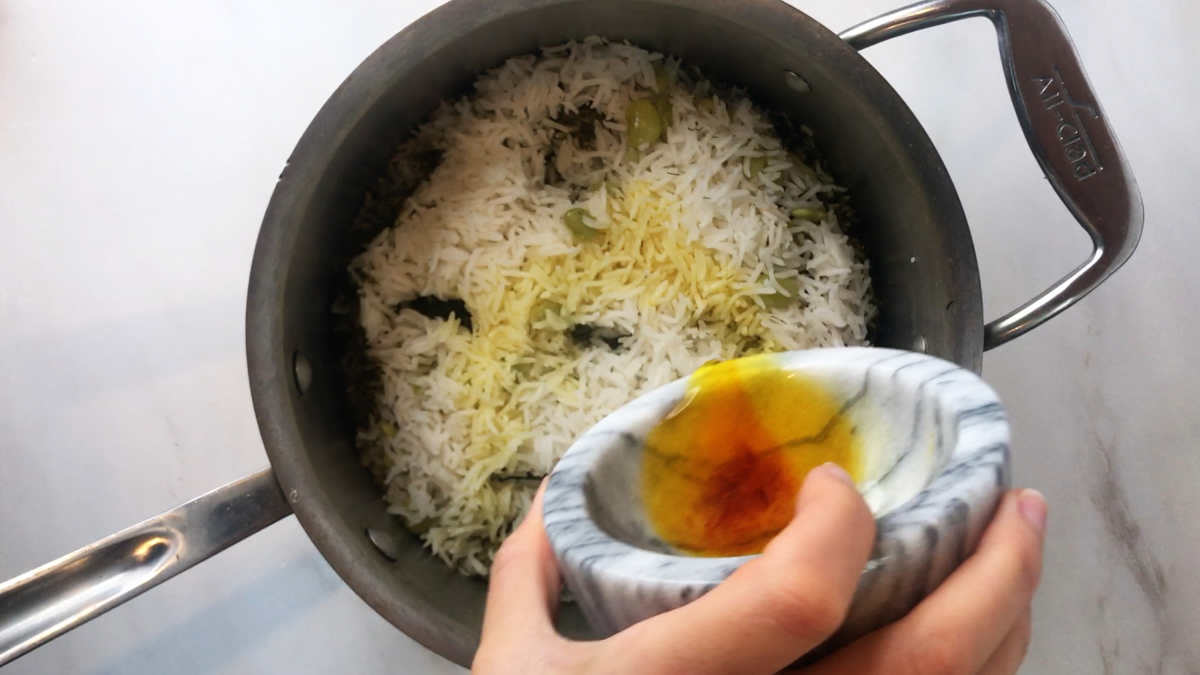 Pouring gold liquid on rice.