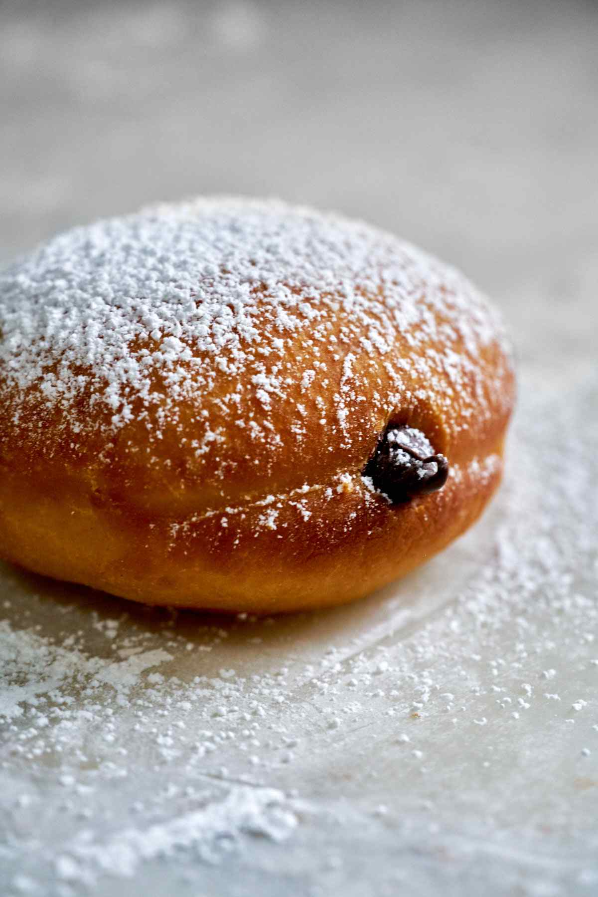 Chocolate filled doughnut with powdered sugar.