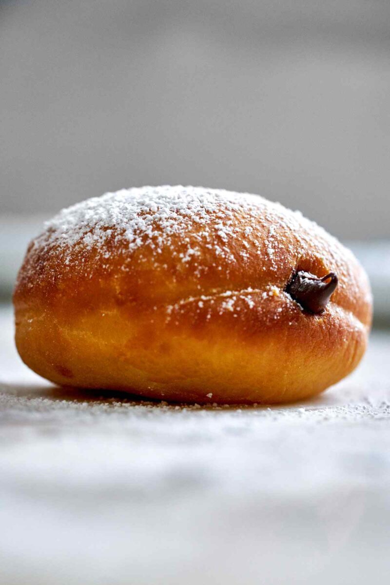 Chocolate filled doughnut with powdered sugar.