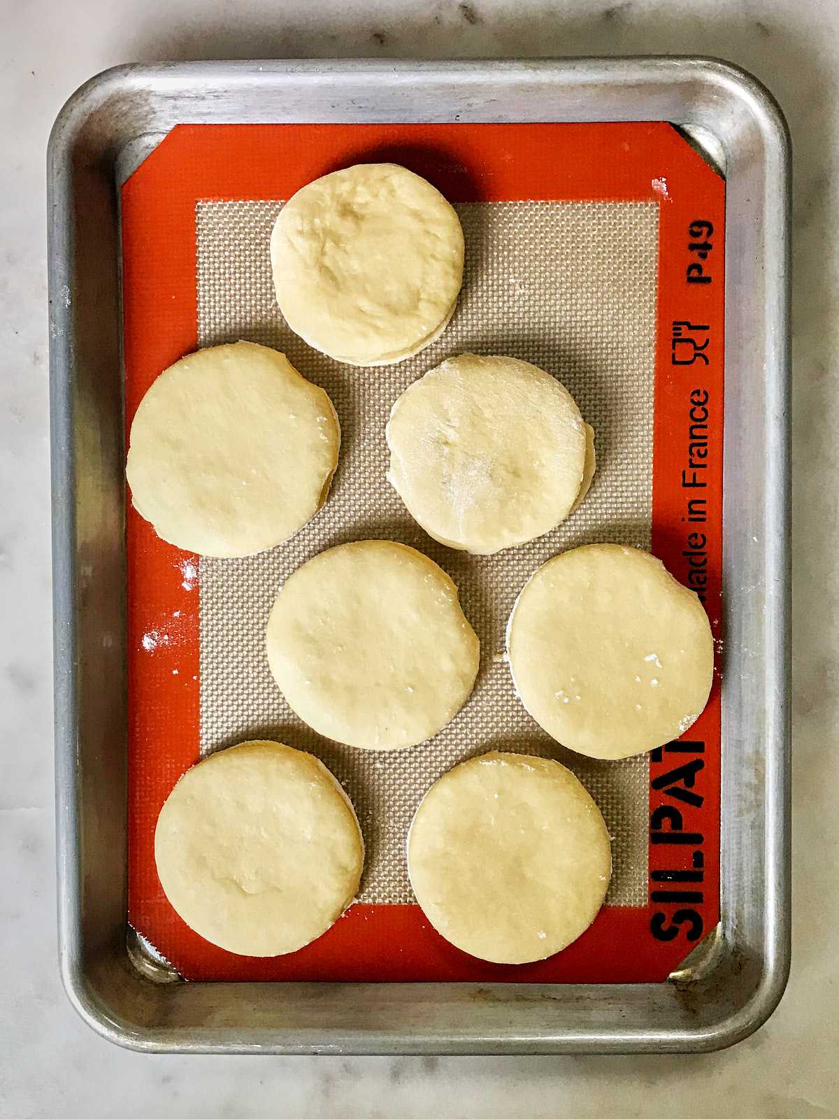 Dough cutouts on a lined baking sheet.