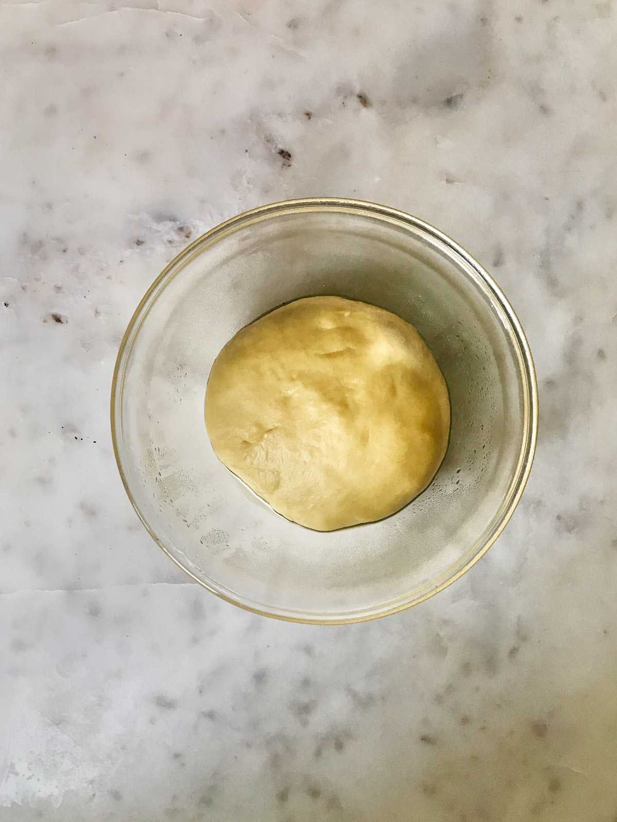 Dough in a glass bowl.