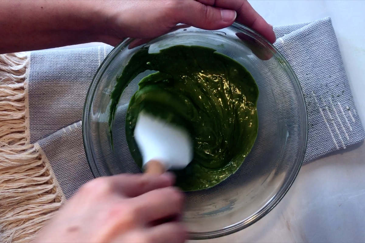 Mixing green chocolate in a bow.