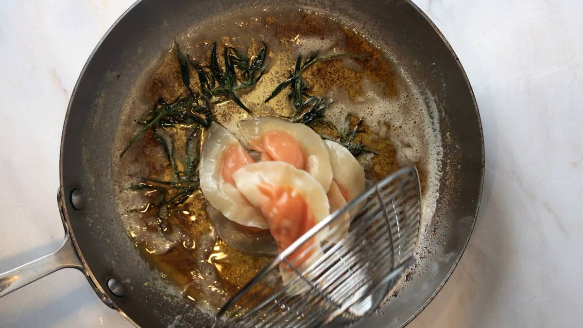 Orange ravioli in a pan.