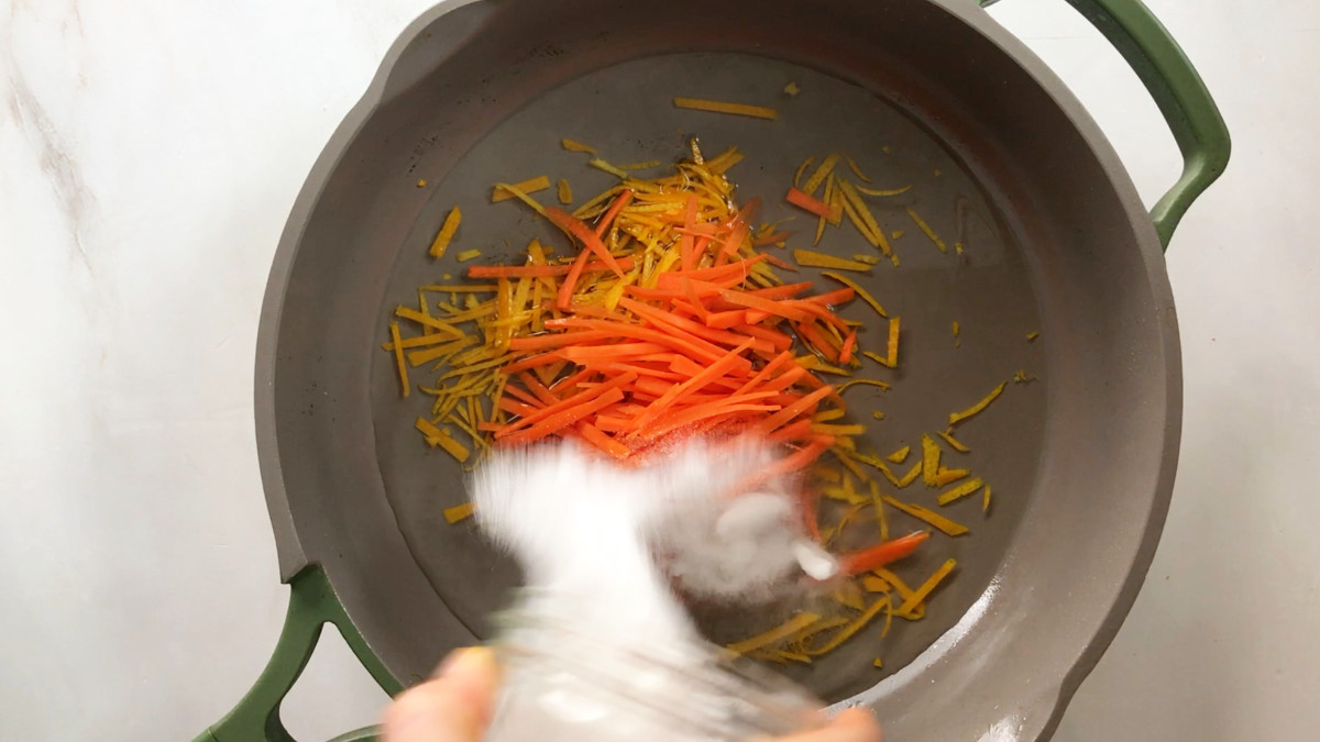 Julienne ingredients in a pan with water.