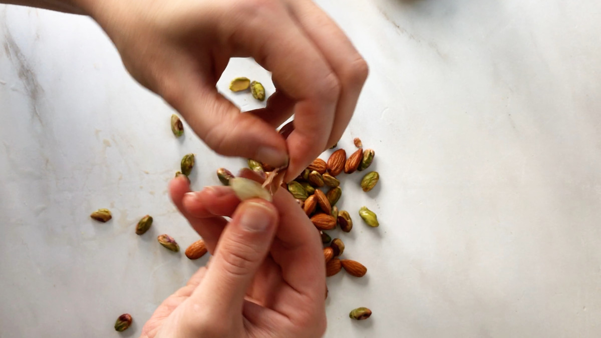 Peeling the skin off an almond.