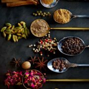 Ground and whole spices on and around spoons.