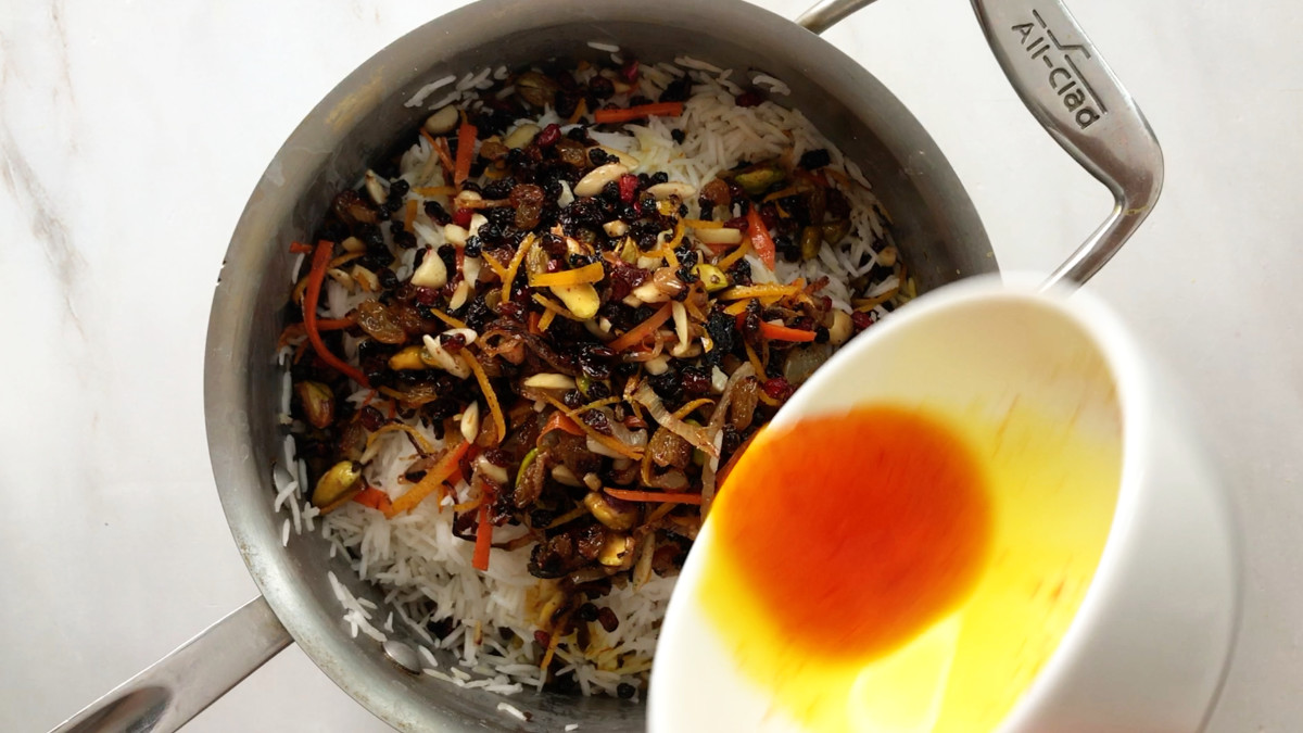 Saffron in a bowl over a pot of rice pilaf.