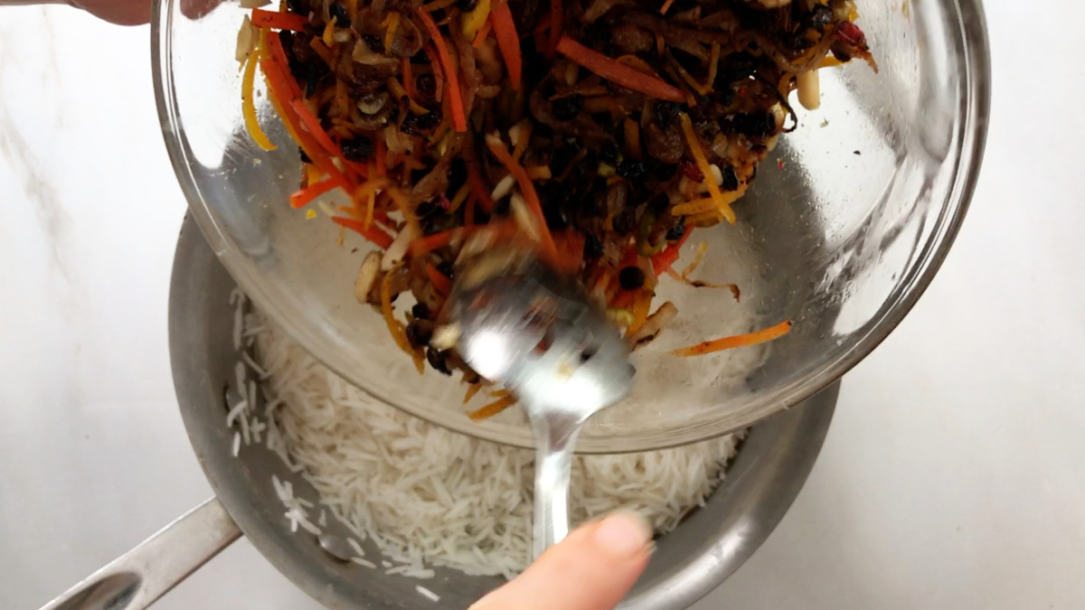 Pouring pilaf ingredients into a pot of rice.