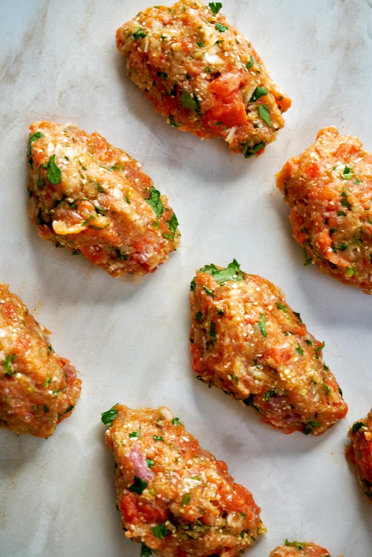 Raw fish cakes on a countertop.