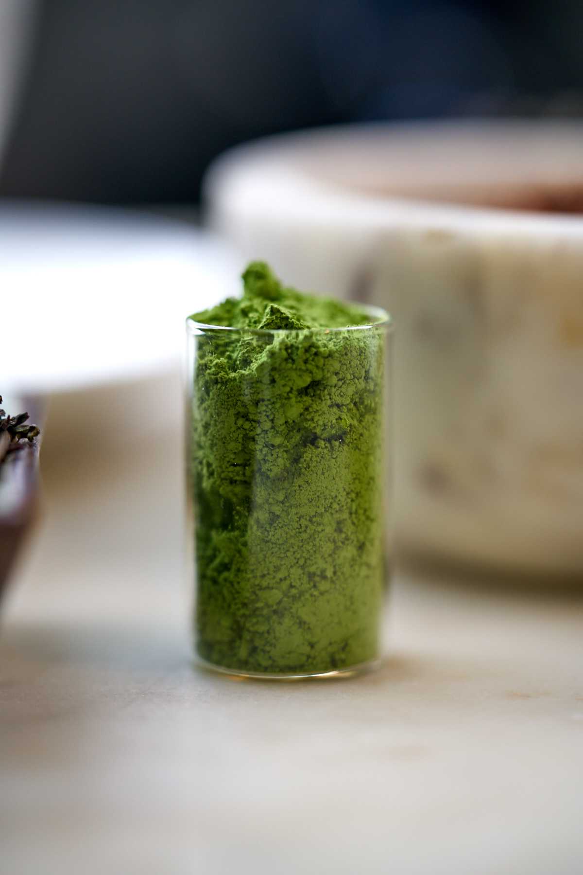 Powdered green tea in a glass vial.