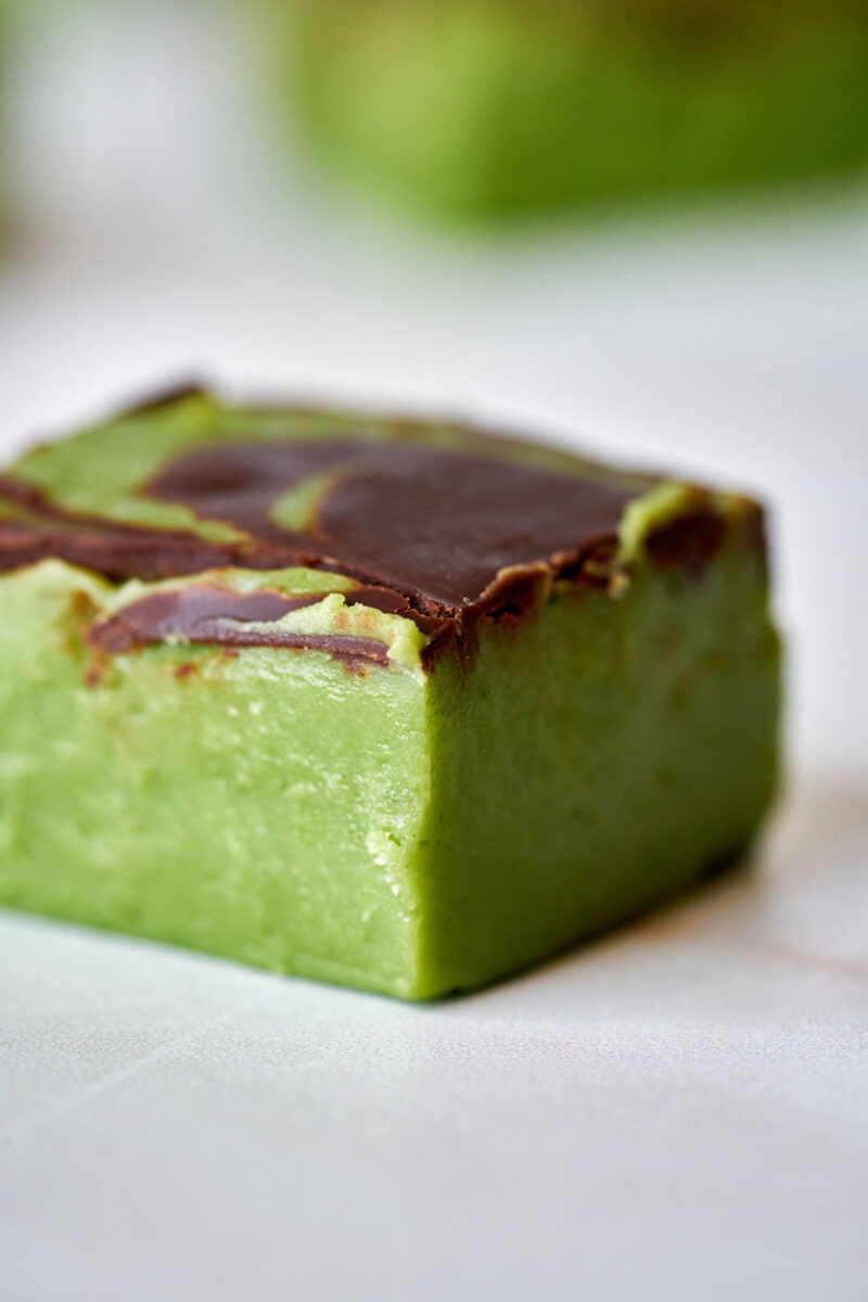 Green fudge cube with chocolate on top.