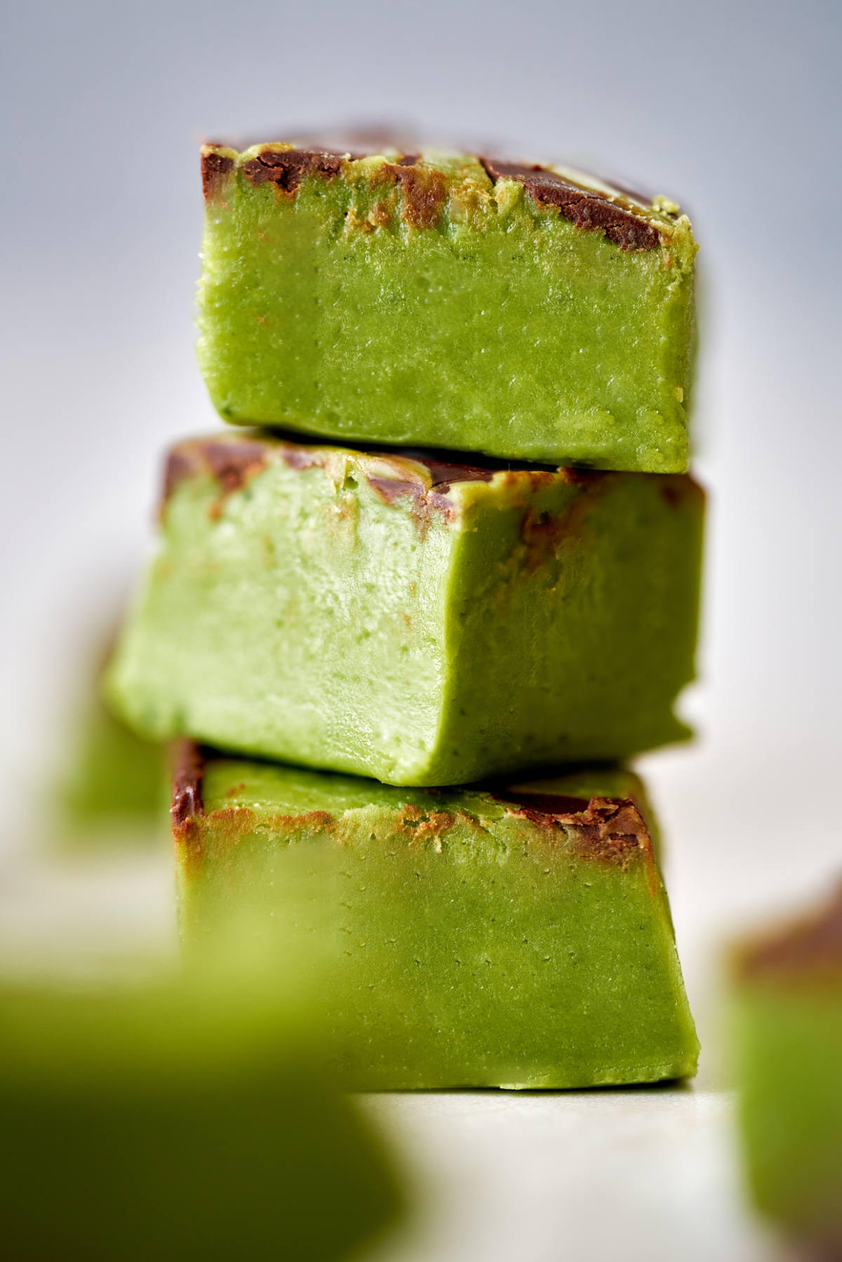 Stack of three square pieces of green fudge.