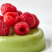 Green panna cotta topped with raspberries.