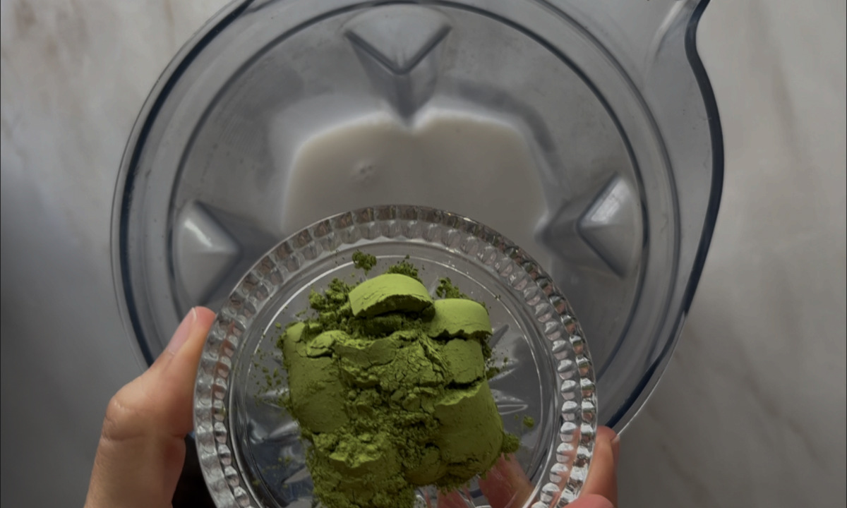 Matcha powder going into a blender.