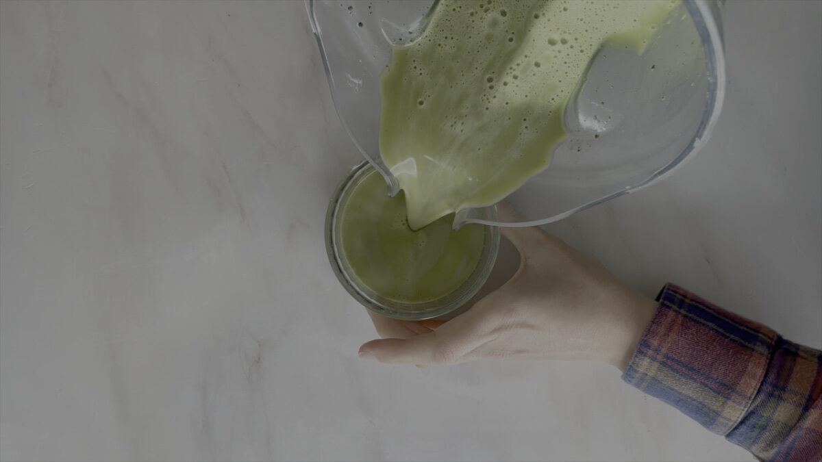 Pouring green liquid from a blender to a ramekin.