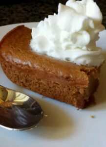 Brown cake with whipped cream and a spoon.