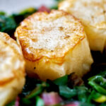 Vegan scallops on a bed of greens.