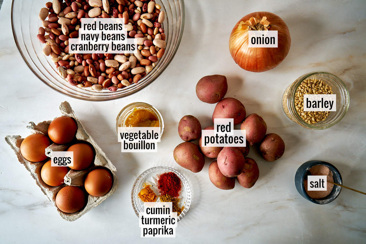 Eggs, potatoes, beans, and other ingredients on a white countertop.