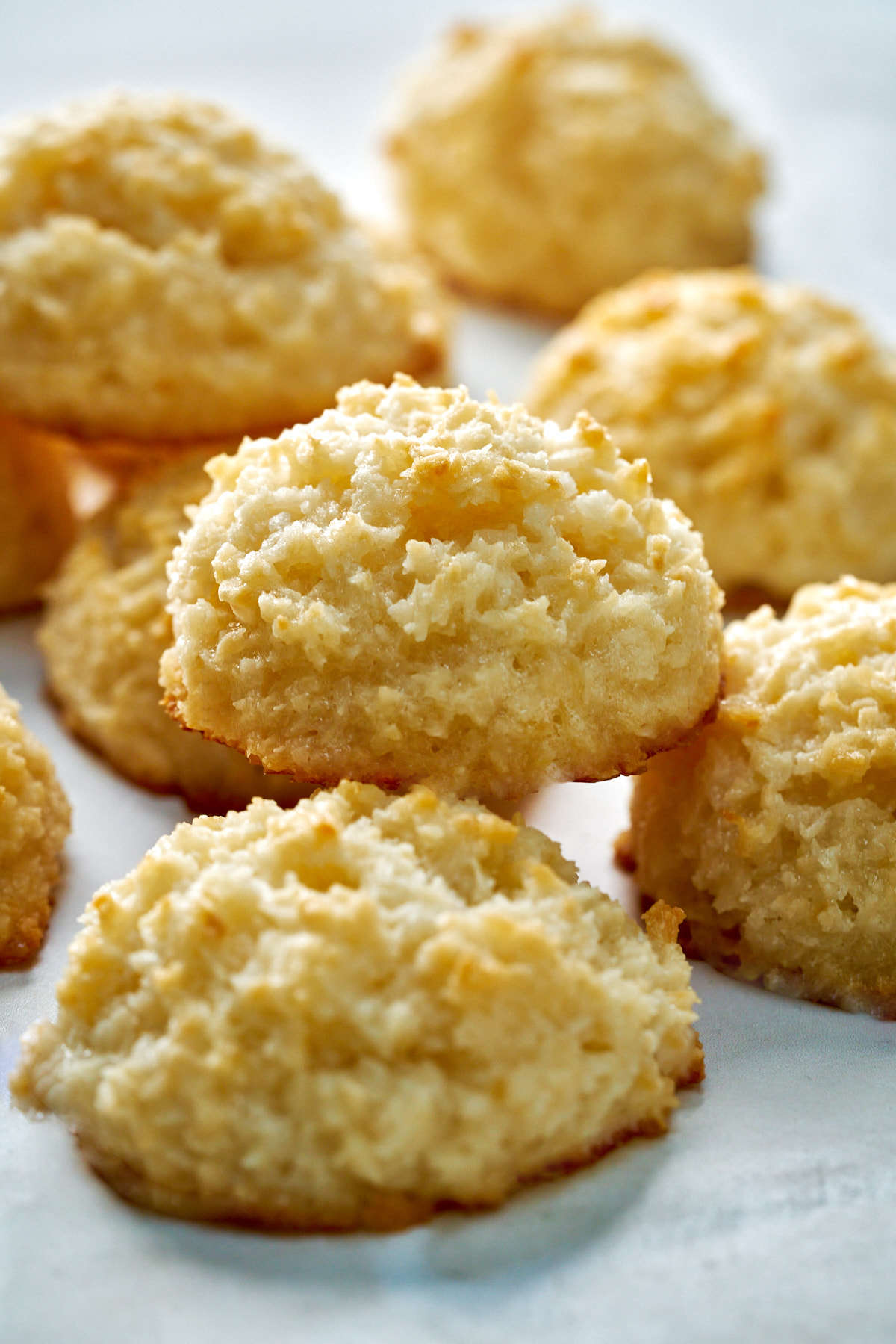 Coconut cookies stacked on a countertop.