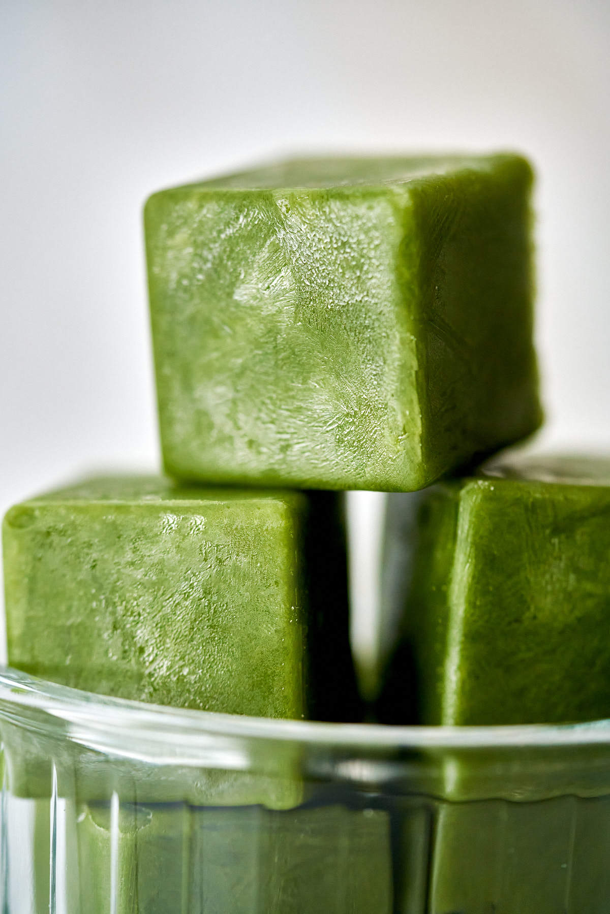 Green ice cubes stacked in a bowl.