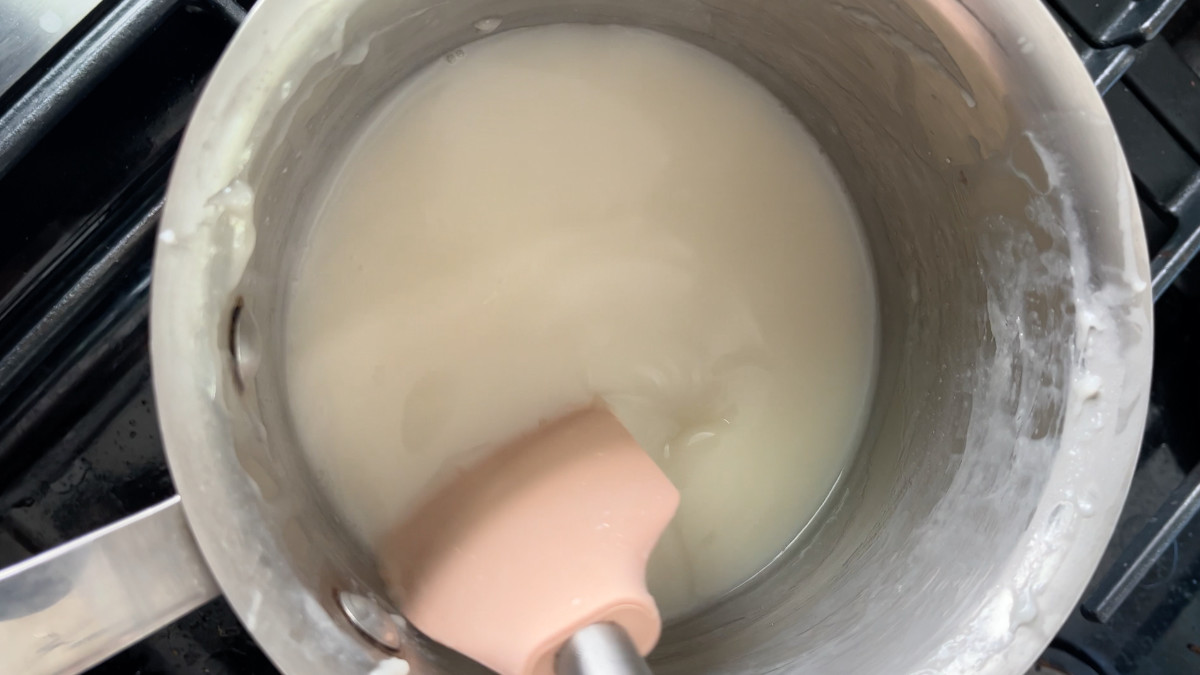 Milk being stirred in a saucepan.