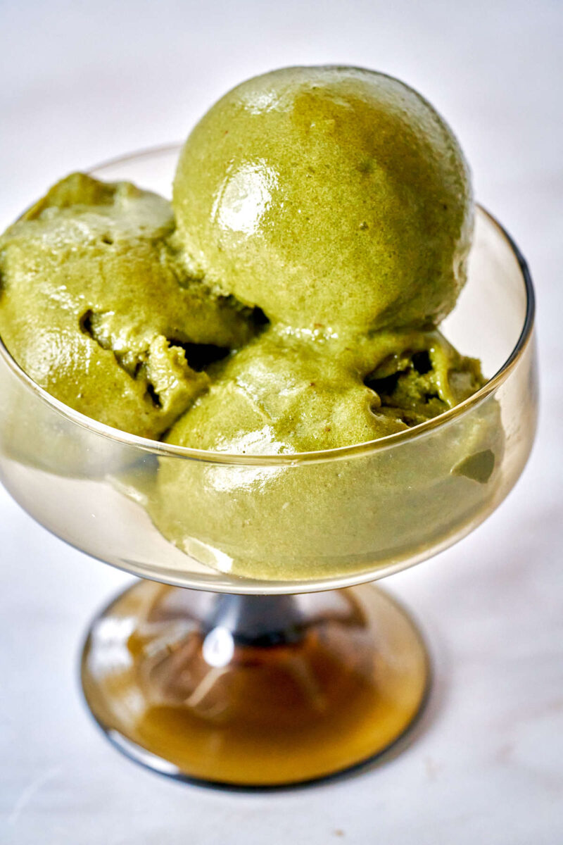 Scoops of green nice cream in a pedestal glass.
