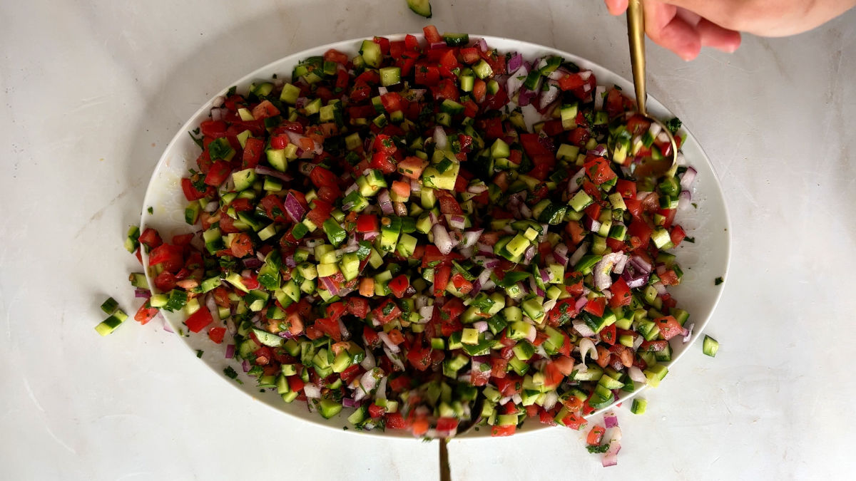 Mixing cucumber tomato salad.