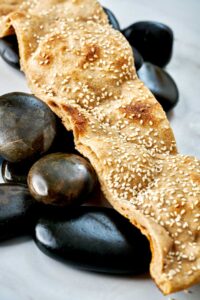 Strip of flatbread laying over rocks.