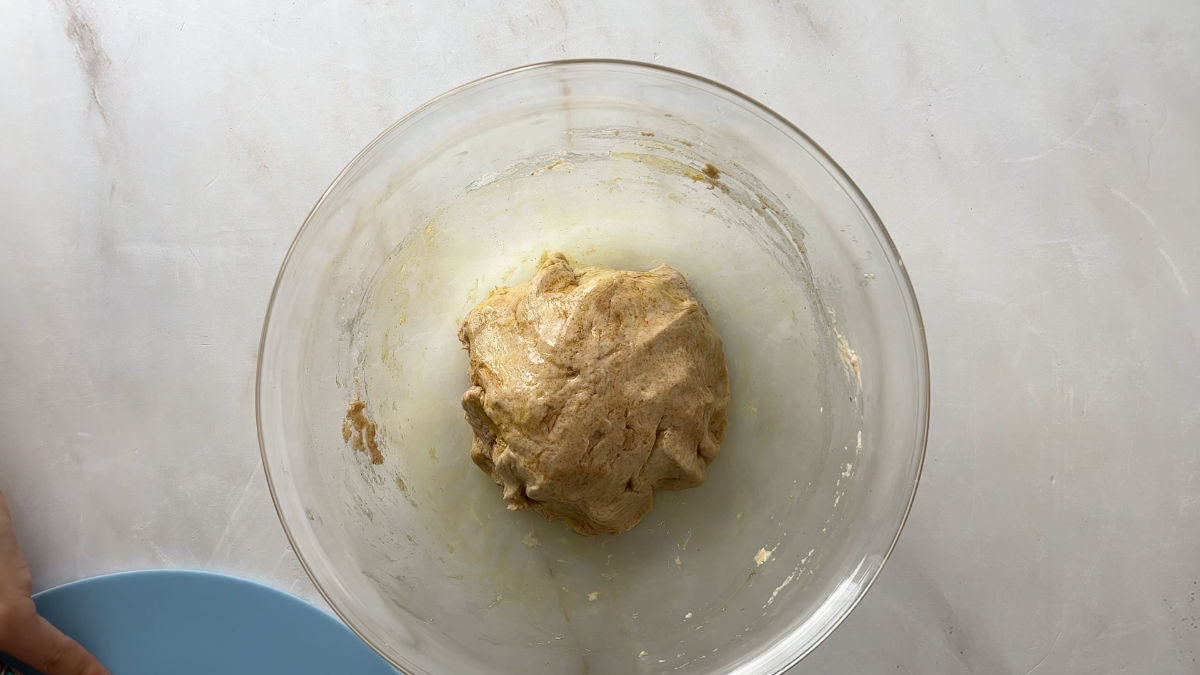 Ball of dough in a glass bowl.