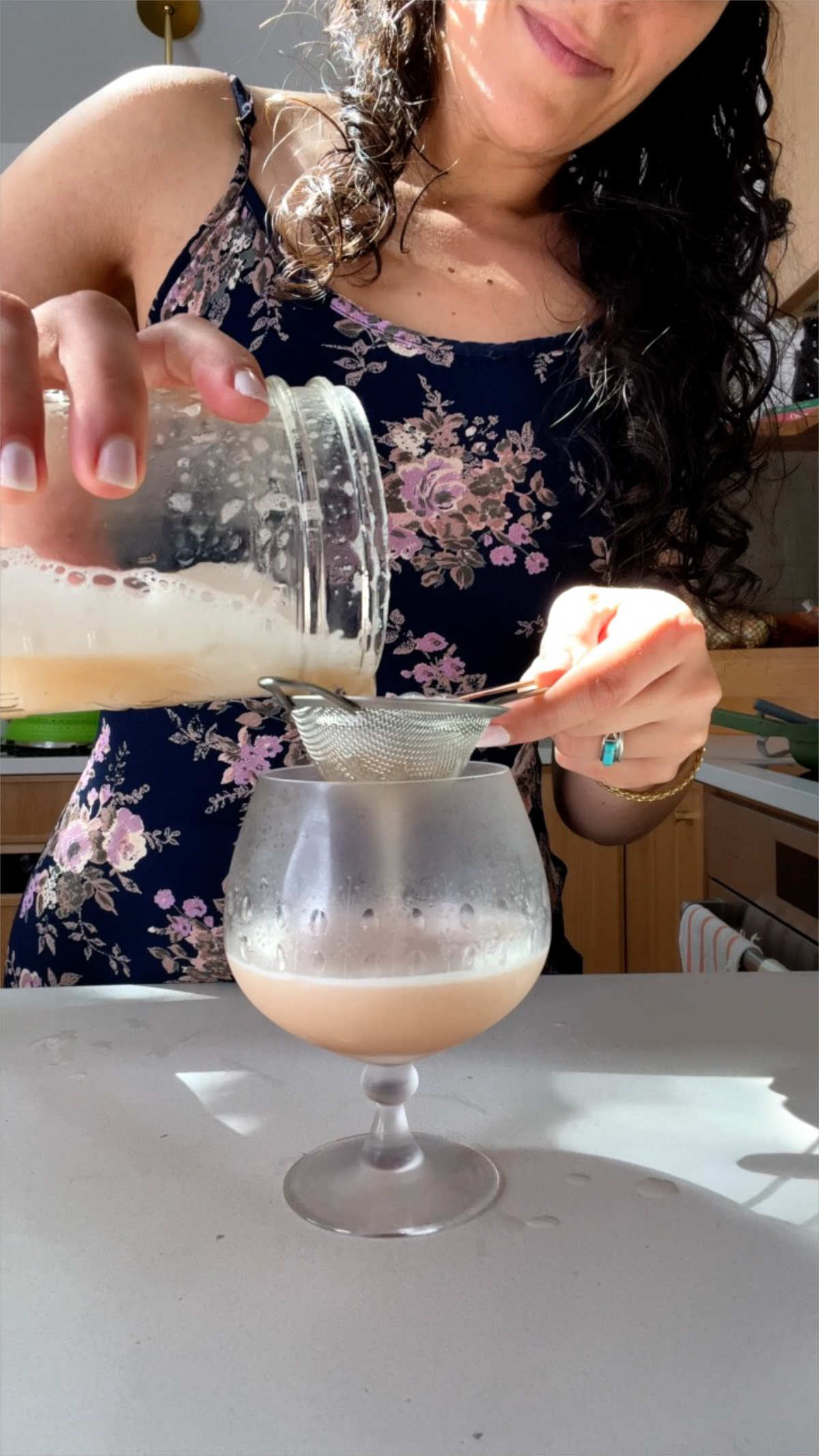 Straining peach liquid into a glass.