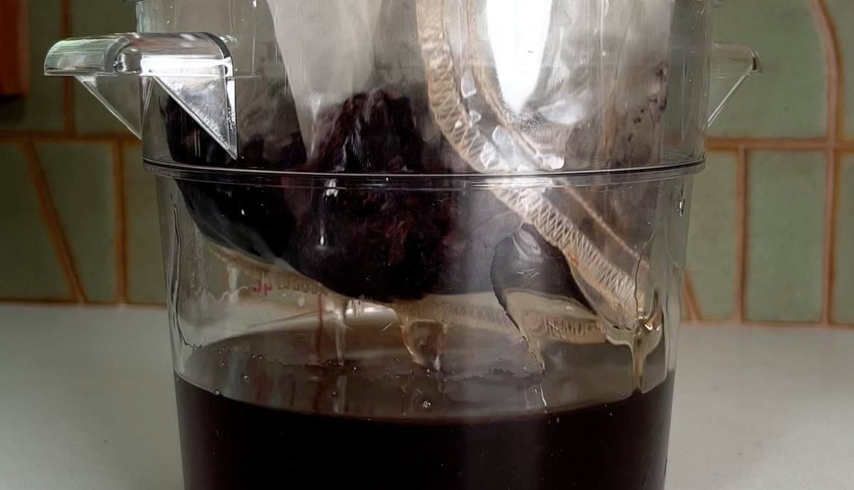 Straining flowers out of simple syrup with a nut milk bag.