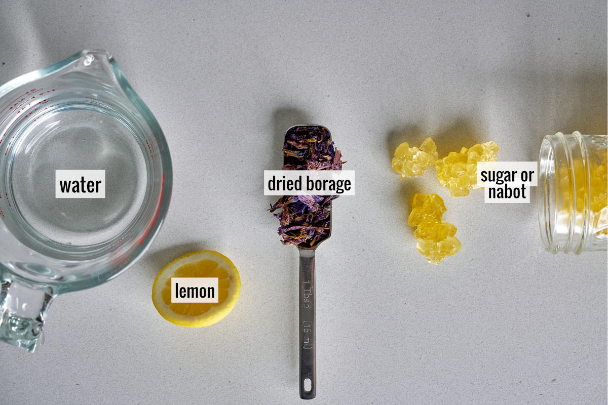 Dried flowers, lemon slice, and yellow rock candy on a countertop.